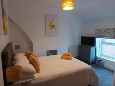 a bedroom with a bed with yellow pillows and a television at Victorian Renovation Room 8 in Liverpool