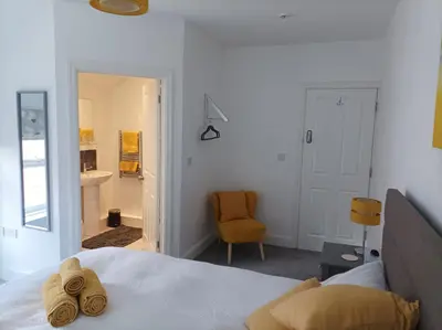 a bedroom with a bed and a chair and a bathroom at Victorian Renovation Room 8 in Liverpool