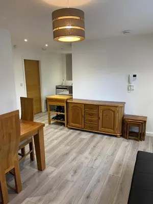 a kitchen with a table and a wooden cabinet at Lovely, Sleeps 8, Cafe Bars, Central Formby in Formby