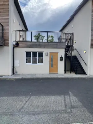 a white building with a staircase and a door at Lovely, Sleeps 8, Cafe Bars, Central Formby in Formby