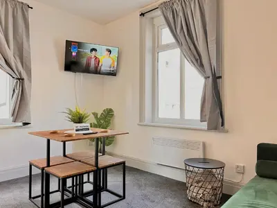 a living room with a table and a window at Spare Property Sasco in Blackpool
