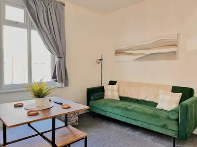 a living room with a green couch and a table at Spare Property Sasco in Blackpool