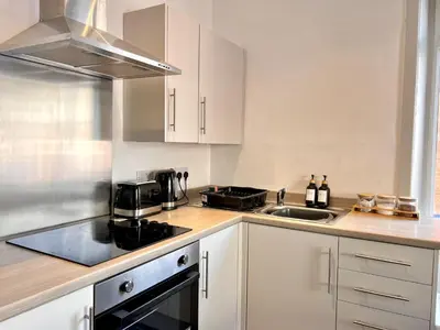 a kitchen with white cabinets and a sink at Spare Property Sasco in Blackpool