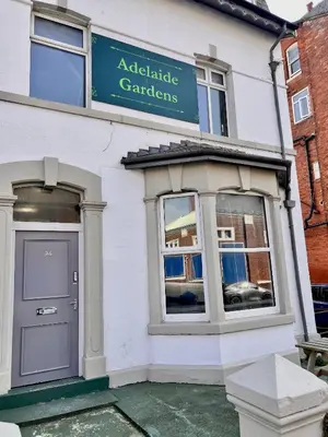 a white building with a sign for agraduate garden at Spare Property Sasco in Blackpool