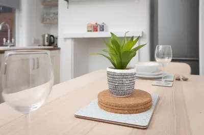 a table with a plant and two glasses of wine at Charles Alexander Short Stay - Ansdell House in Blackpool