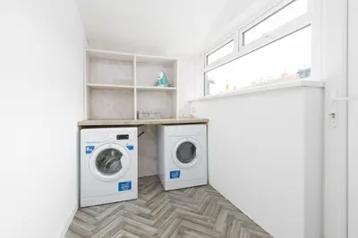 a laundry room with two washing machines and a window at Charles Alexander Short Stay - Ansdell House in Blackpool