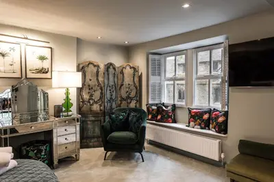 a bedroom with a chair and a desk and windows at Number 10 in Whalley