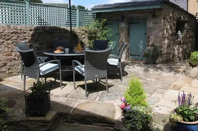 a patio with a table and chairs in a yard at Number 10 in Whalley
