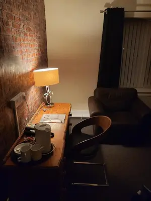 a living room with a table with a lamp and a couch at Jubilee pub in Litherland
