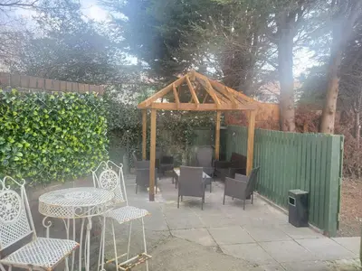 a patio with a table and chairs and a gazebo at Jubilee pub in Litherland