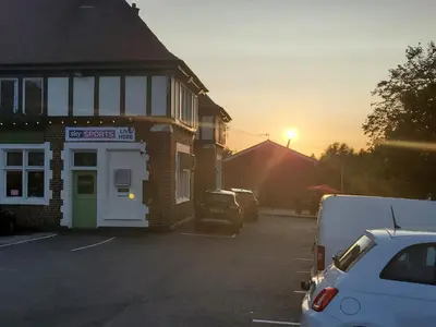 a parking lot with cars parked in front of a building at Jubilee pub in Litherland
