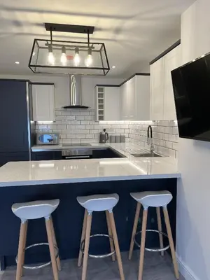 a kitchen with two bar stools at a counter at 20 Coop Street Apartments in Blackpool
