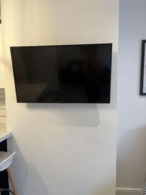 a flat screen tv hanging on a white wall at 20 Coop Street Apartments in Blackpool