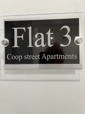 a sign on a door that says flap and croop street apartments at 20 Coop Street Apartments in Blackpool