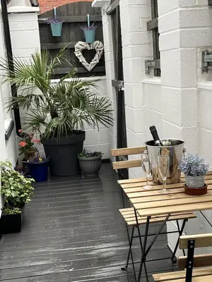 a wooden table and bench on a patio with potted plants at 20 Coop Street Apartments in Blackpool