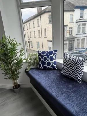a bench in a window with pillows and a plant at 20 Coop Street Apartments in Blackpool