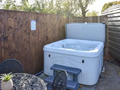 a bath tub sitting next to a wooden fence at Privet Pod - Uk41394 in Westhead