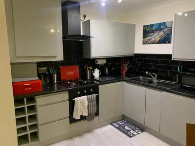 a kitchen with white cabinets and a sink at Modern 2 bed apartment in Wallasey
