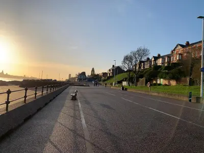 a person riding a skateboard down a street at Modern 2 bed apartment in Wallasey