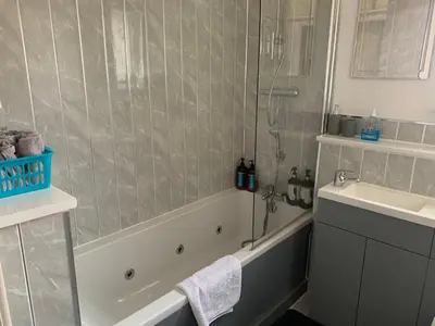 a bathroom with a shower and a tub and a sink at Modern 2 bed apartment in Wallasey