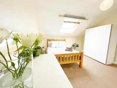 a bedroom with a bed and a table with flowers at Liverpool Townhouse - 5 bedroom, great transport links in Liverpool