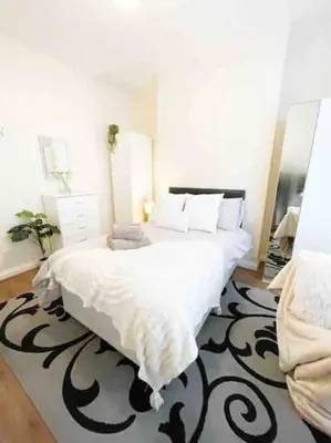 a bedroom with a large bed with a black and white blanket at Liverpool Townhouse - 5 bedroom, great transport links in Liverpool