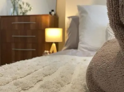 a bedroom with a bed with a dresser and a lamp at Liverpool Townhouse - 5 bedroom, great transport links in Liverpool
