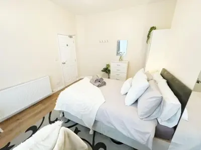 a bedroom with a bed with white sheets and pillows at Liverpool Townhouse - 5 bedroom, great transport links in Liverpool