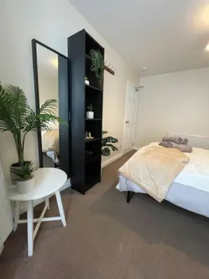 a bedroom with a bed and a table and a mirror at Liverpool Townhouse - 5 bedroom, great transport links in Liverpool