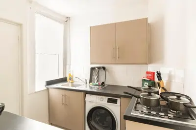 a kitchen with a washing machine and a washer at 3-bedroom Home in Liverpool L15 with FREE Parking in Liverpool