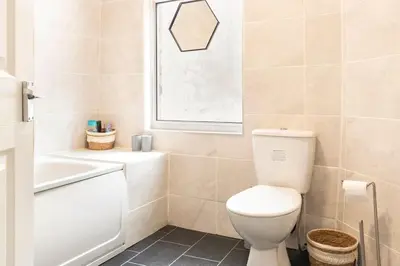 a bathroom with a toilet and a sink and a window at 3-bedroom Home in Liverpool L15 with FREE Parking in Liverpool