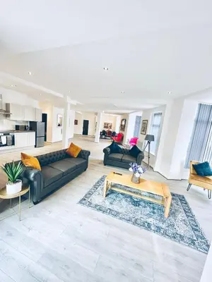 a living room with black couches and a coffee table at Winter Gardens Royal Suite Blackpool in Blackpool