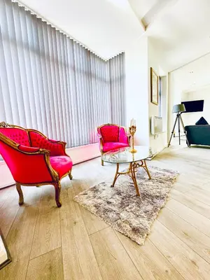 a living room with two chairs and a table at Winter Gardens Royal Suite Blackpool in Blackpool