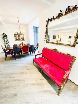 a red bench in a room with a mirror at Winter Gardens Royal Suite Blackpool in Blackpool