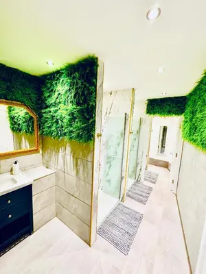 a bathroom with green plants on the walls at Winter Gardens Royal Suite Blackpool in Blackpool