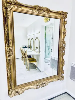 a gold mirror hanging on a wall with a dining room at Winter Gardens Royal Suite Blackpool in Blackpool