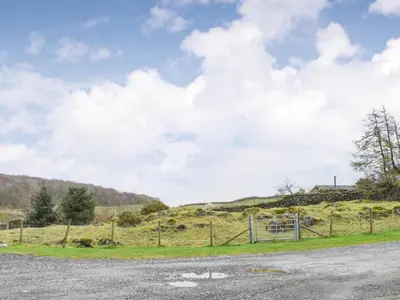 a field with a fence on the side of a road at Methera Cottage - Uk41487 in Spark Bridge