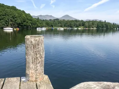 a wooden post on the end of a dock on a lake at Methera Cottage - Uk41487 in Spark Bridge