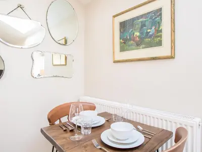 a dining room with a wooden table and a mirror at Methera Cottage - Uk41487 in Spark Bridge