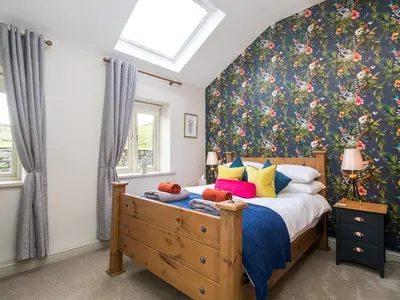 a bedroom with a bed with a floral wallpaper at Methera Cottage - Uk41487 in Spark Bridge