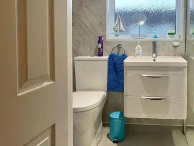 a bathroom with a white toilet and a sink at The Bay Cottage in Thornton