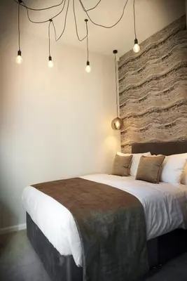 a bedroom with a large bed with a stone wall at Home at 2 Tancred Road Anfield in Liverpool