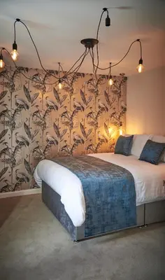 a bedroom with a large bed with a floral wallpaper at Home at 2 Tancred Road Anfield in Liverpool