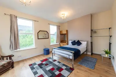 a bedroom with a bed and a rug at Chestnut Heritage,- Large & Cheerful 5 bedroom house with free parking in Liverpool