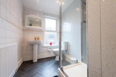 a bathroom with a toilet and a sink and a shower at Chestnut Heritage,- Large & Cheerful 5 bedroom house with free parking in Liverpool