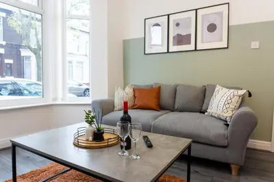 a living room with a couch and a table with wine glasses at Keith House - Air Host & Stay - Free Parking in Liverpool
