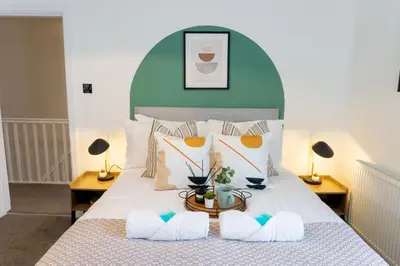 a bedroom with a bed with a blue headboard at Keith House - Air Host & Stay - Free Parking in Liverpool