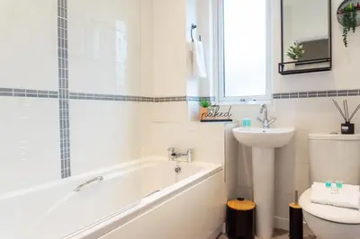 a bathroom with a tub and a sink and a toilet at Keith House - Air Host & Stay - Free Parking in Liverpool