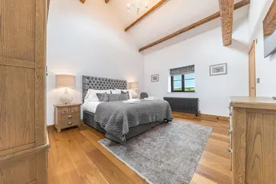 a bedroom with a bed and a wooden floor at Old Stable in Ulverston