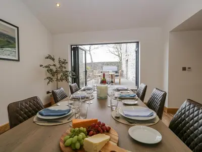 a dining room with a table with food on it at Old Stable in Ulverston